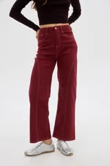 Pantalón jean color bordó de corte recto, tiro alto, con costuras pespunteadas en contraste y bolsillos delanteros y traseros.