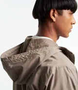 Campera rompevientos color verde oliva con capucha ajustable con cordón, cierre frontal con cremallera, bolsillos laterales con cremallera, puños con elástico y forro interior. Ligera y versátil, ideal para proteger del viento y la lluvia ligera.