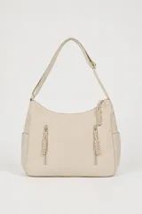 Cartera tipo hobo de nylon color beige, con correa ajustable para el hombro, cierre principal superior y dos bolsillos frontales verticales con cierre y tiradores trenzados. Cuenta además con bolsillos laterales abiertos.