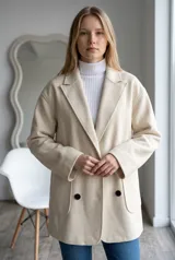 Tapado de paño color marrón, de corte oversize, con solapas clásicas, cierre frontal de doble botonadura y bolsillos laterales de parche.