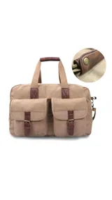 Bolso tipo maletín de tela canvas color beige con detalles en cuero sintético marrón. Cuenta con dos bolsillos frontales con tapa y cierre de hebilla, cierre superior, doble asa de mano y correa larga ajustable y desmontable.