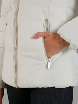 Campera acolchada de Calvin Klein en color blanco, confeccionada en una mezcla de poliéster y elastano que ofrece elasticidad y confort. Presenta un diseño con cuello alto, capucha, cierre frontal de cremallera metálica y bolsillos laterales con cierre. Su acabado tiene un ligero brillo y cuenta con un calce entallado gracias a sus costuras horizontales.