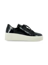 Sneaker de cuero charol negro con suela de plataforma blanca. Presenta cordones al tono y un diseño minimalista de caña baja.