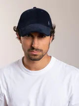 Gorra de pana color camel con visera curva y logo bordado en el lateral.