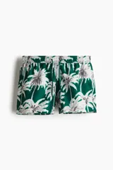 Short de baño con estampado de palmeras en tonos verdes y blancos, cuenta con cintura elástica con cordón ajustable, bolsillos laterales, un bolsillo trasero y suspensor interior de malla.