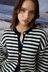 Cardigan de punto con diseño de rayas horizontales en blanco y negro, cuello redondo y cierre frontal con botones de colores.