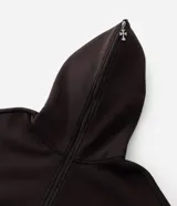 Buzo canguro marrón oscuro con capucha, cierre frontal completo y bolsillos, confeccionado en mezcla de algodón y poliéster con interior de felpa. Presenta una estampa en la espalda y mangas con diseño de huesos en tono beige claro con efecto desgastado.