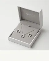 Set compuesto por collar y aros de acero italiano, con diseño de herradura adornado con circonias engastadas.