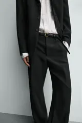 Pantalón de traje con corte relaxed fit, confeccionado en una mezcla de viscosa y lino. Presenta bolsillos laterales delanteros, bolsillos traseros de vivo y cierre frontal con cremallera y gancho oculto.