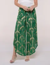 Pantalón palazzo verde de gasa con sutil transparencia y estampa metalizada dorada. Presenta cintura elastizada con cordón ajustable terminado en borlas y diseño de piernas anchas cruzadas en el frente con terminación de puntilla en los bordes.