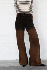 Jean de mujer de corte recto y tiro alto, con efecto degradado de negro a marrón. Presenta costuras verticales en la parte delantera y bolsillos laterales.