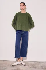 Sweater de lana color rojo, con cuello redondo, mangas largas y detalle de costura decorativa en los laterales.