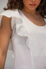 Vestido largo de algodón tusor en color blanco, con volados en las sisas que simulan mangas y aberturas laterales en la falda.