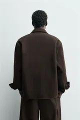 Sobrecamisa de corte regular confeccionada en tejido con mezcla de lana, color marrón oscuro. Presenta cuello solapa, cierre frontal con botones, mangas largas con puños abotonados y bolsillos laterales.
