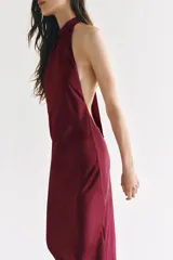 Vestido largo satinado de color bordó, con cuello halter fruncido y diseño sin mangas.