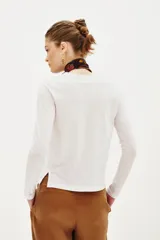 Remera de manga larga color marrón oscuro, con cuello redondo y corte holgado.