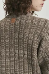 Sweater de tejido de punto con diseño de trenzas y efecto mouliné, cuello redondo y terminaciones en rib en puños y ruedo.