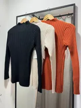 Buzo de punto acanalado con cuello alto, manga larga y corte ajustado.