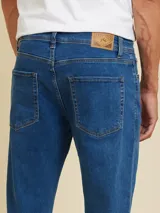 Pantalón de jean azul claro, corte recto, con bolsillos delanteros y traseros.