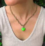 Collar dorado de doble cadena, una de eslabones gruesos y otra fina, con dije de corazón esmaltado color verde.