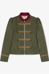 Blazer corto de estilo militar confeccionado en terciopelo azul marino, con cuello mao, cierre frontal con cremallera, detalles de galones bordados y botones metálicos decorativos.