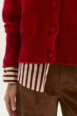 Cardigan de tejido de punto en color marrón, con cuello en V, cierre frontal de botones y detalle de bordado en una de las mangas.