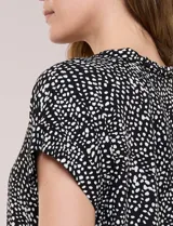 Camisa de manga corta con estampado animal print, cuello con solapa, escote en V y cierre frontal con botones.