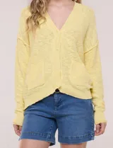 Cardigan blanco de punto liviano y texturado, de corte holgado y diseño casual. Cuenta con escote en V pronunciado, abotonadura frontal, mangas largas con hombros caídos y bolsillos delanteros tipo parche.