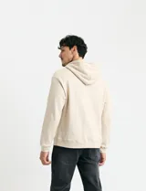 Sweater deportivo con capucha, bolsillo canguro frontal y cordones de ajuste. Presenta un diseño de color azul oscuro con interior de capucha en color verde.