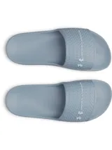 Ojotas Under Armour modelo W Armr Slide Lite de color gris, confeccionadas en EVA moldeada de una sola pieza. Presenta una tira ancha con textura geométrica y el logo de la marca en relieve.