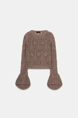 Jersey de punto marrón topo con diseño calado de flores y mangas largas terminadas en volantes acampanados.