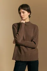 Polera de cuello alto confeccionada en tejido de punto negro, con diseño de textura acanalada en cuello, puños y ruedo, y trama vertical en mangas y espalda.