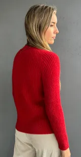 Sweater de punto color rojo con diseño de ochos en el frente y tejido morley en mangas y espalda. Presenta cuello redondo a la base, manga larga y calce ajustado.
