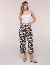 Pantalón cropped de pierna ancha y tiro alto, con diseño estampado floral en color marrón y blanco. Cuenta con pretina elástica en la parte trasera y bolsillos laterales.