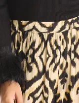 Falda midi de corte acampanado con diseño de estampado tribal en tonos negro y amarillo. Presenta una pretina ancha elastizada para mayor comodidad.