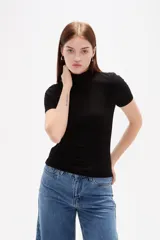Remera de viscosa con textura acanalada, corte al cuerpo, cuello alto y mangas cortas.