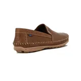 Zapato tipo mocasín o náutico de hombre, color negro, con costura artesanal visible alrededor del empeine y puntera. Presenta perforaciones tipo picado en la parte frontal y un pequeño detalle de etiqueta roja en el lateral.