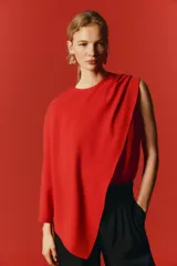 Blusa roja sin mangas en mezcla de viscosa, con escote redondo y diseño asimétrico de efecto capa con pliegues en un lateral.