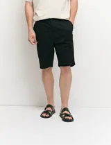 Bermuda chino de corte recto, color verde militar, confeccionada en algodón con elastano. Cuenta con bolsillos laterales de estilo italiano y bolsillos traseros con botón.
