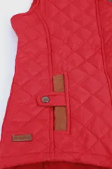 Chaleco beige capitoneado con cierre frontal y cuello de pana marrón.