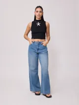 Jean de corte wide leg con tiro medio, confeccionado en denim de algodón en tono azul medio con efecto lavado.