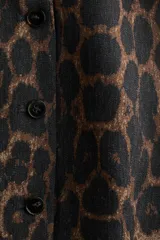 Chaleco de sastrería entallado, con escote cuadrado, breteles anchos y cierre frontal de botones. Presenta un diseño con estampado animal print de leopardo en tonos marrones y negros.