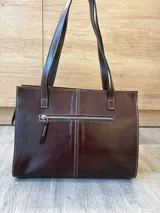 Cartera tipo shopper de cuero genuino marrón con panel central de textura símil cocodrilo y herrajes metálicos plateados.