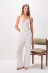 Pantalón de pijama blanco de algodón con textura acanalada, corte holgado y diseño recto.