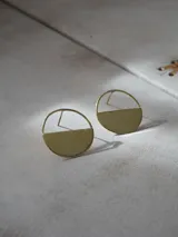 Aros colgantes plateados de diseño geométrico, formados por un aro circular con la mitad inferior sólida y texturada.