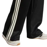 Pantalón de chándal Adidas negro de corte holgado, con cintura elástica ajustable con cordón, bolsillos laterales, ribetes de satén y las tres rayas blancas características de la marca a lo largo de las piernas. Logo de Adidas en la parte superior de la pierna izquierda.
