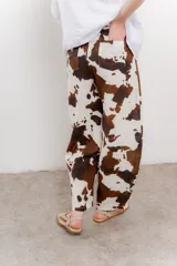 Pantalón ancho de lino con estampado de manchas de vaca en tonos marrón y blanco. Incluye cinturón de soga trenzada con flecos.