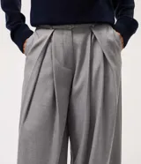 Pantalón de sastrería modelo pantalona, de corte amplio y tiro alto. Presenta pinzas frontales, cierre con cremallera y botón, y presillas en la cintura. Incluye un cinturón ajustable del mismo tejido.