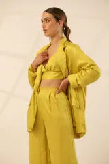 Blazer verde esmeralda de seda con solapas y botón blanco.