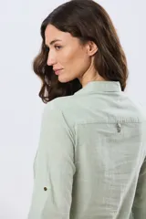Camisa de lino lisa color celeste, de manga larga con puños abotonados y trabilla para arremangar. Cuenta con cuello clásico, cierre frontal con botones y bolsillos plaqué en el pecho.